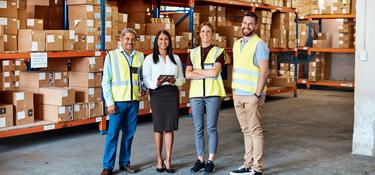 Four team members in a warehouse 