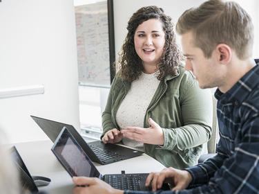 Denver team members collaborate while working on their laptops