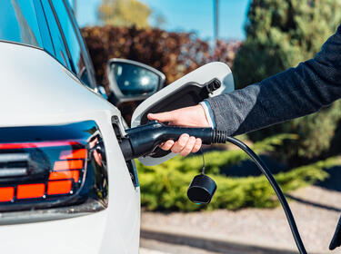A person charging their EV vehicle A person charging their EV vehicle