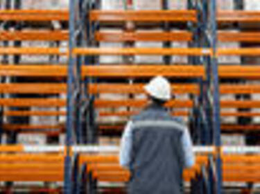 Man standing in front of Orange Racking in a warehouse