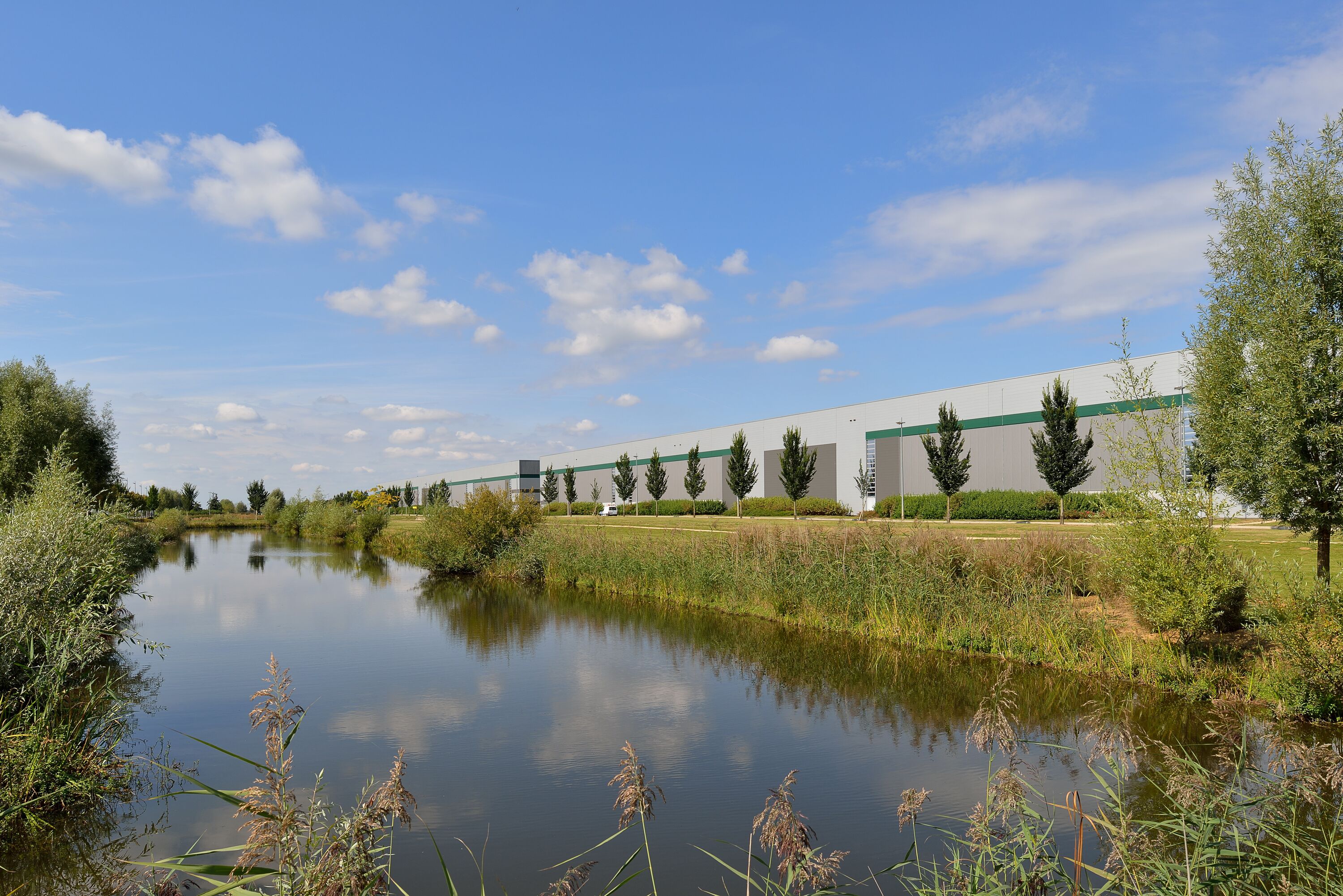 Ein Lagerhaus mit Bäumen und einem Fluss im Hintergrund Ein Lagerhaus mit Bäumen und einem Fluss im Hintergrund